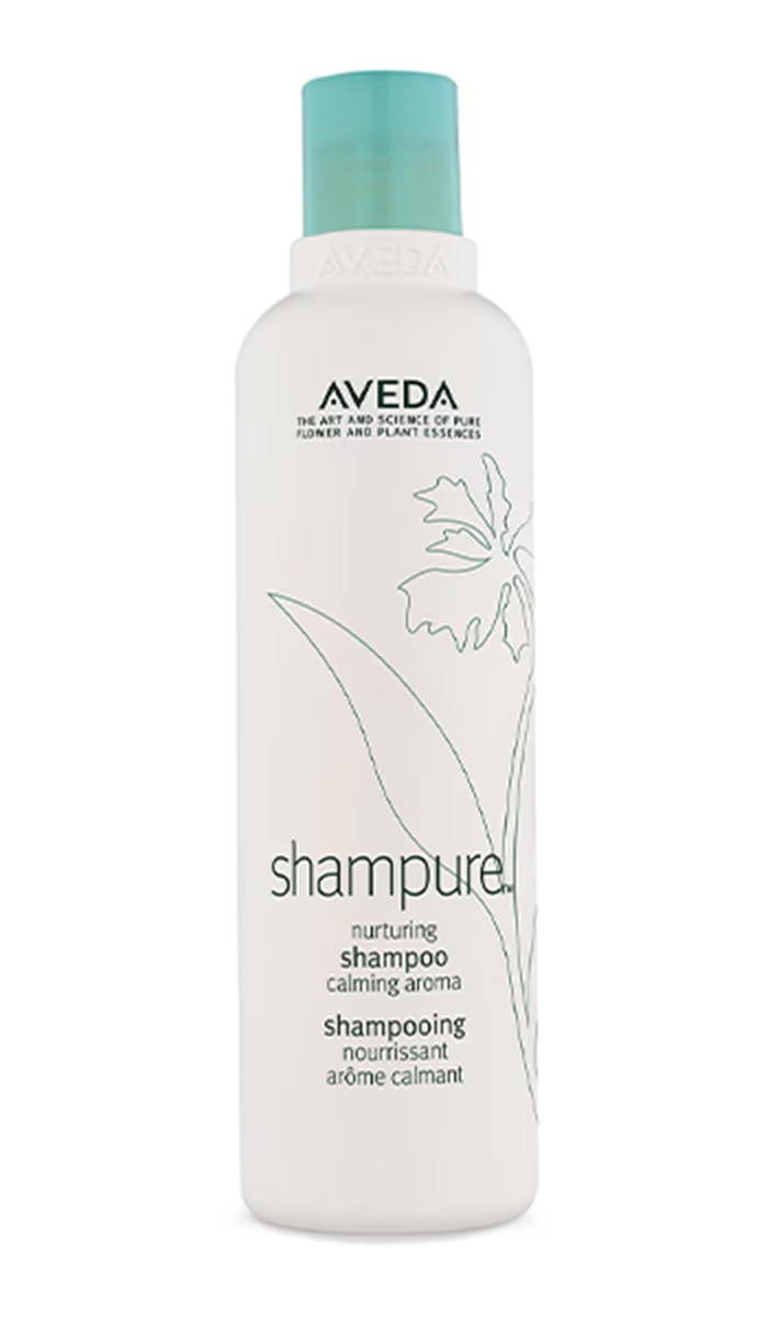Aveda Shampure nurturing shampoo in a sleek white bottle with a light teal cap, featuring a calming aroma for gentle hair cleansing.